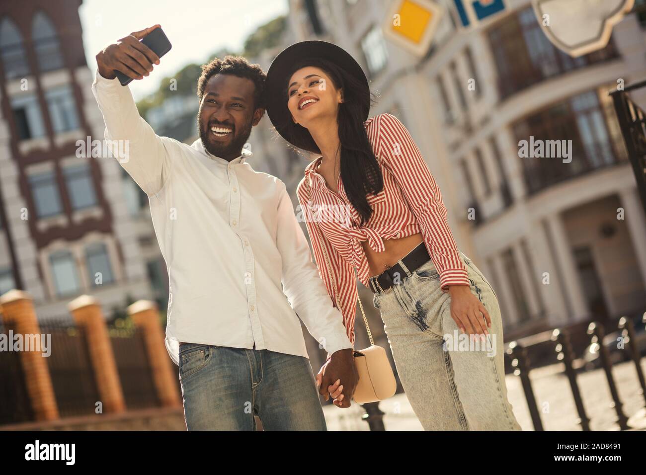 Felice coppia giovane tenendo selfie in strada Foto Stock