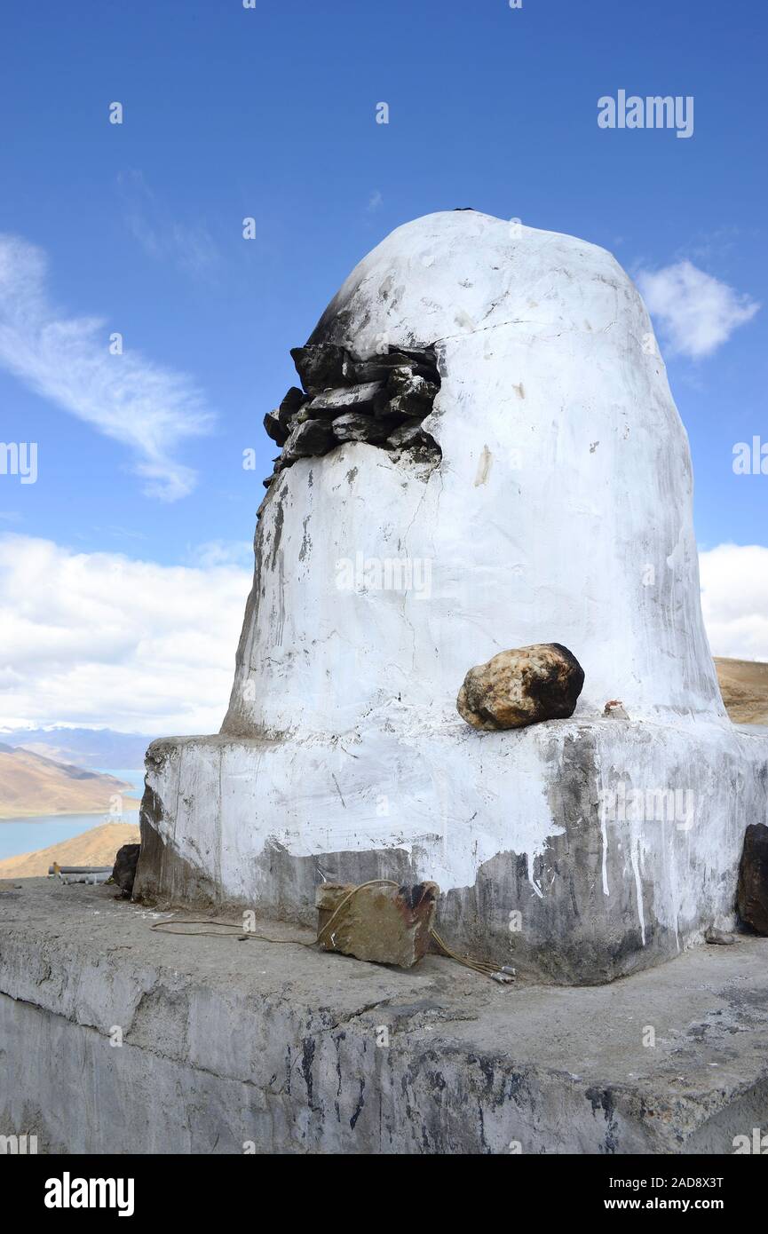 Una struttura utilizzata per bruciare incenso segna un si affacciano sul lago Yamdrok in Brahmaputra Valley della regione autonoma del Tibet, Cina. Foto Stock