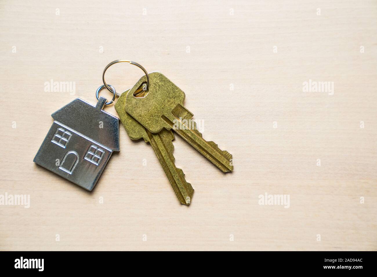 Le chiavi di casa e portachiavi su sfondo di legno Foto Stock