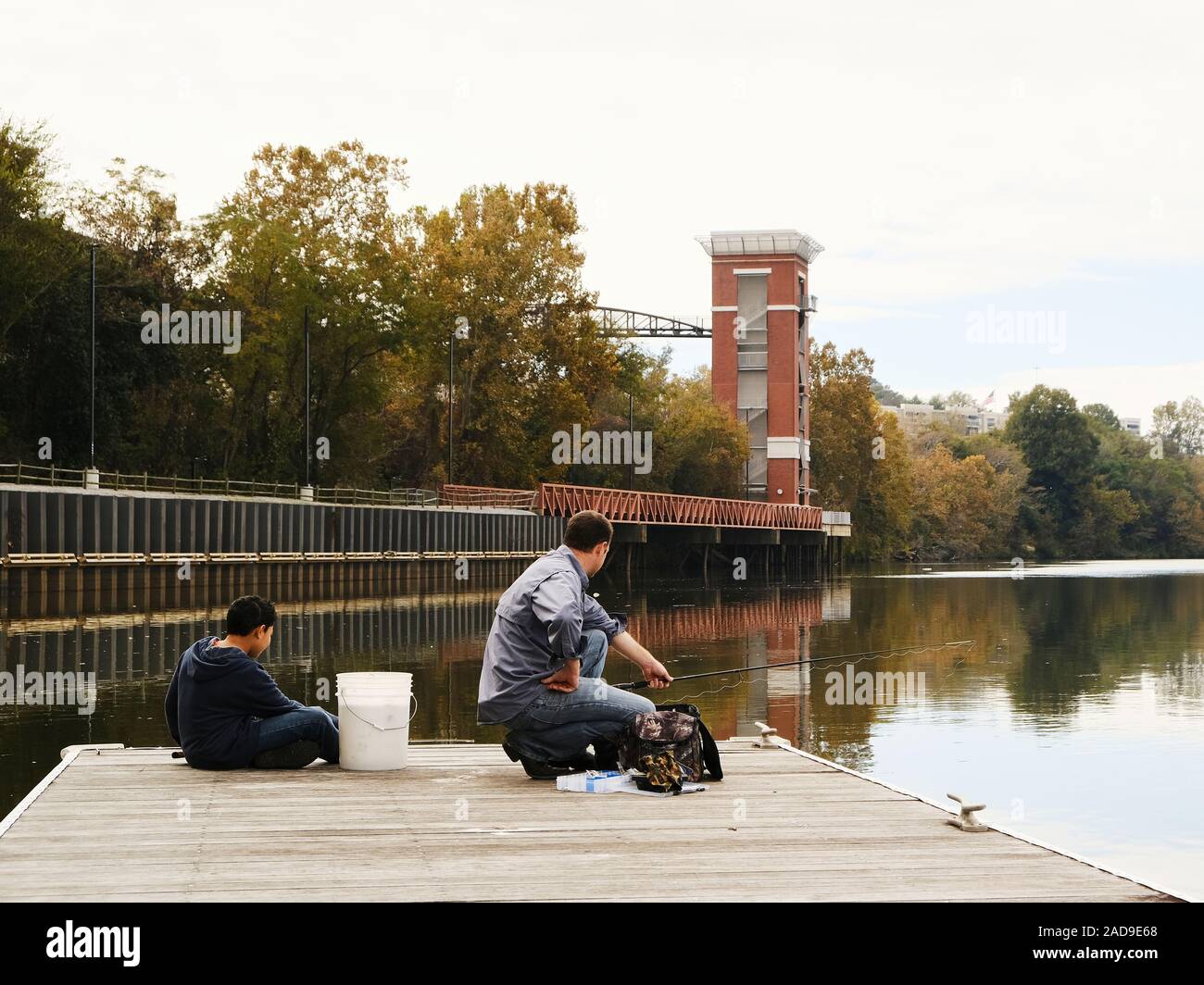 Padre e figlio o uomo e ragazzo di pesca su un molo sul Fiume Alabama a Montgomery in Alabama, Stati Uniti d'America. Foto Stock