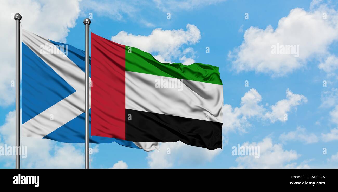 La Scozia e la Bandiera degli Emirati Arabi Uniti sventolare nel vento contro bianco torbido cielo blu insieme. Concetto di Diplomazia e relazioni internazionali. Foto Stock