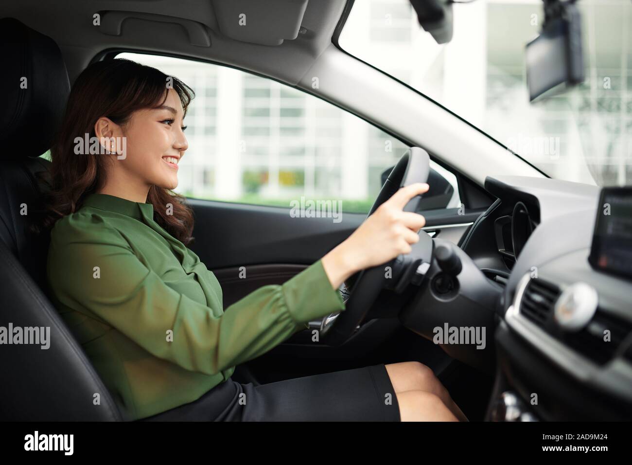 Giovane bella donna alla guida la sua automobile Foto Stock
