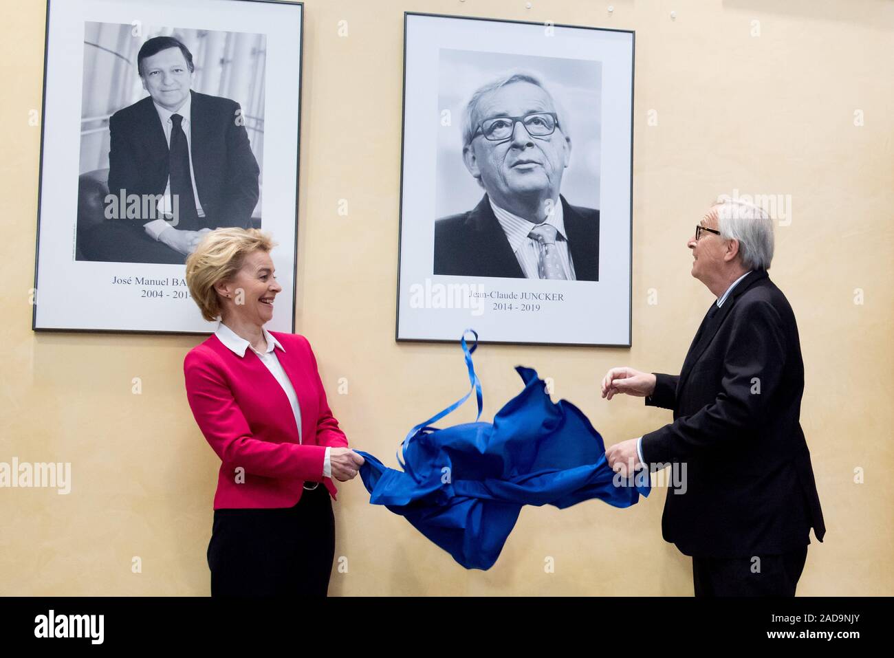(191204) -- Pechino, il 4 dicembre, 2019 (Xinhua) -- Il Presidente della Commissione europea, Ursula von der Leyen (L) e il suo predecessore Jean Claude Juncker svelare un ritratto di Juncker ad un ufficiale di cerimonia di consegna presso la sede centrale della Commissione europea a Bruxelles, Belgio, Dicembre 3, 2019. (Commissione Europea/Handout via Xinhua) Foto Stock