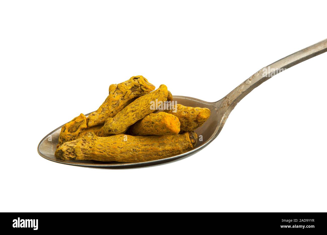 Essiccata la curcuma radice in un vecchio cucchiaio isolato su uno sfondo bianco. Condimento su isolare. Vista da sopra. Foto Stock
