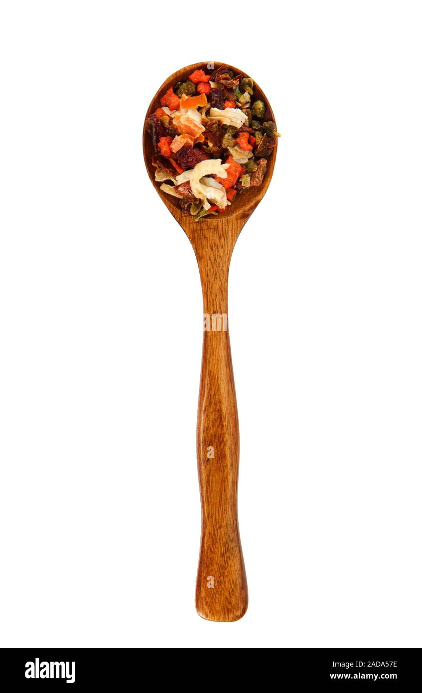 Una miscela di peperoni in un cucchiaio di legno su isolare. Vista da sopra. La stagionatura in un cucchiaio. Asciugare le spezie. Foto Stock