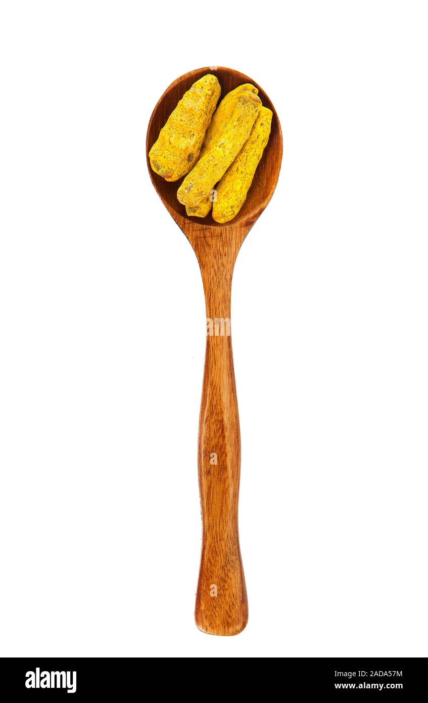 Essiccata la curcuma radice in un cucchiaio di legno su isolare. Condimento su isolare. Vista da sopra. Asciugare le spezie. Foto Stock