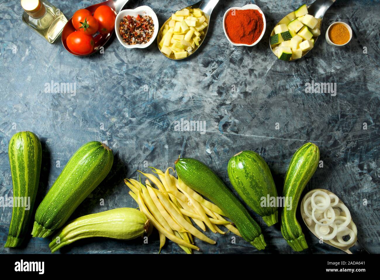 Verdure sullo sfondo. Ortaggi freschi (cetrioli, pomodori, cipolle, aglio, aneto, fagioli verdi) su sfondo grigio. A Foto Stock