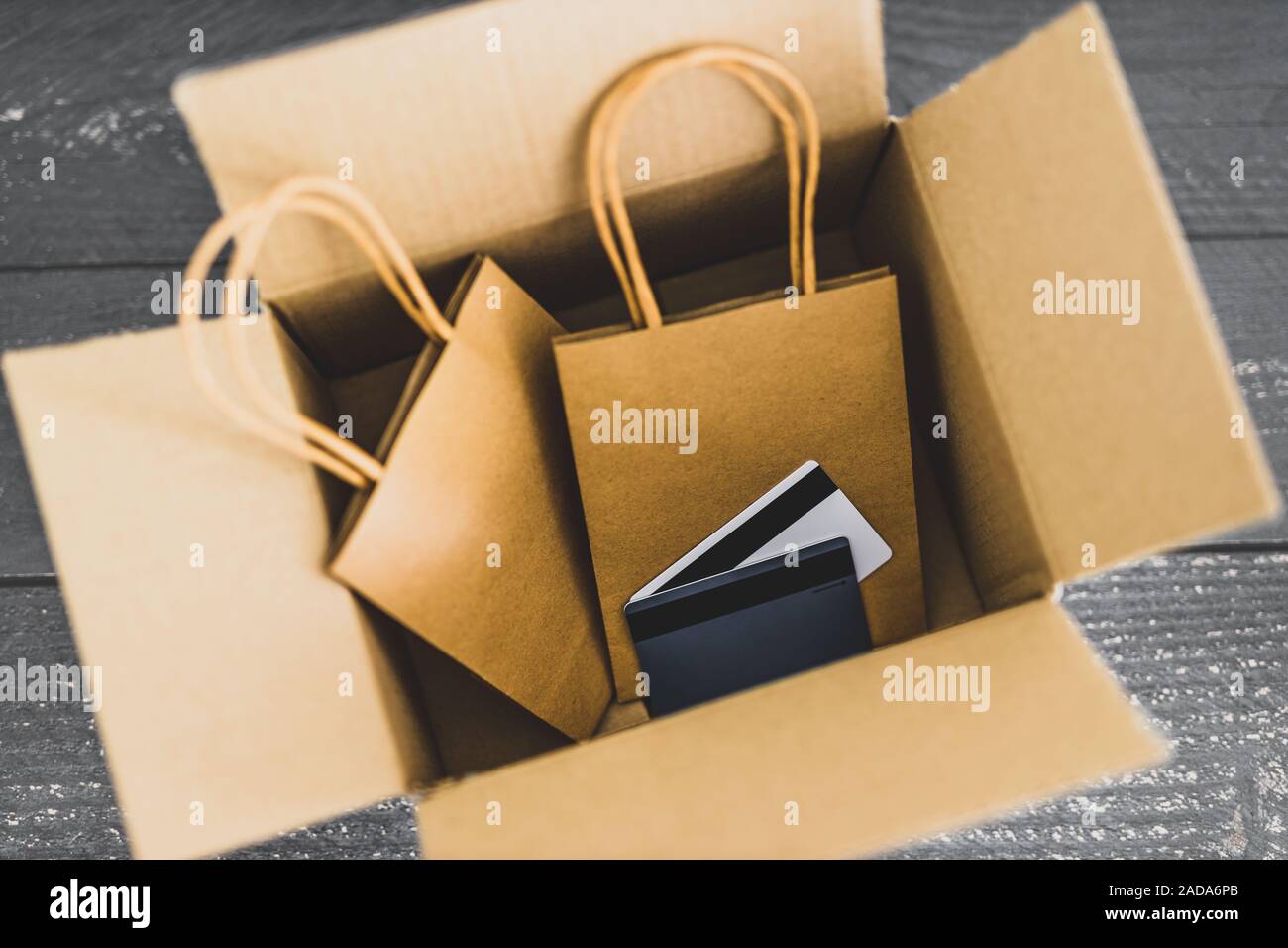 Ordini online conceptual still-life, borse per lo shopping all'interno di aprire il pacco di consegna con carte di pagamento sulla parte superiore Foto Stock