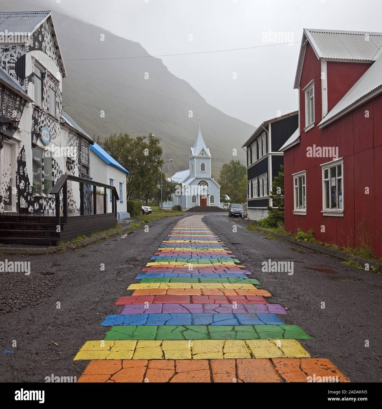 Rainbow strisce sul modo per la Chiesa, Seydisfjoerdur, Est Islanda Islanda Foto Stock