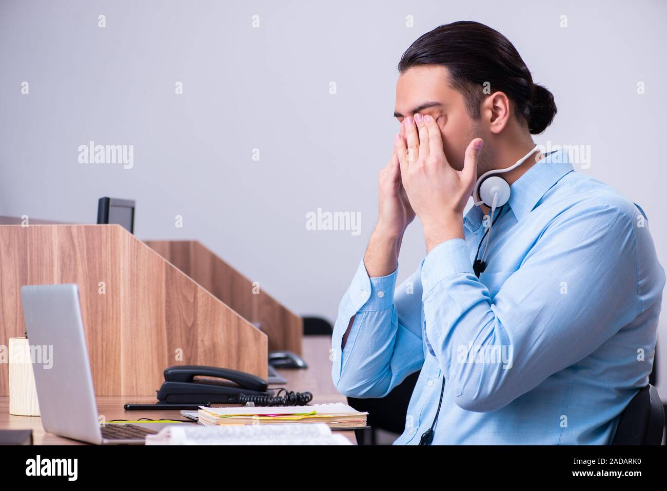 Operatore di call center al lavoro presso la sua scrivania Foto Stock