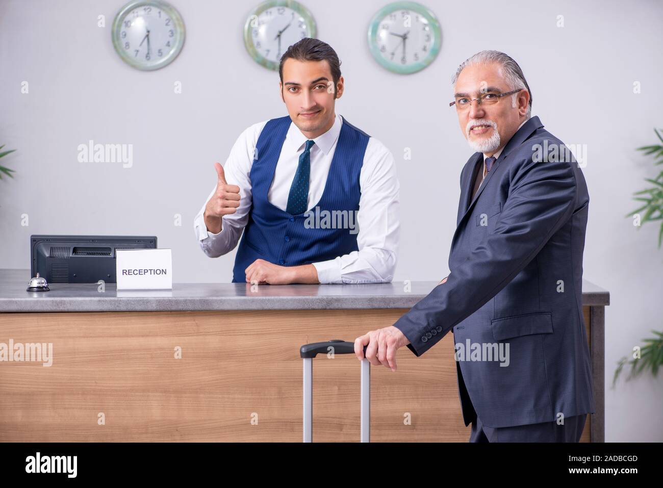 Il vecchio uomo d affari presso la reception dell' hotel Foto Stock