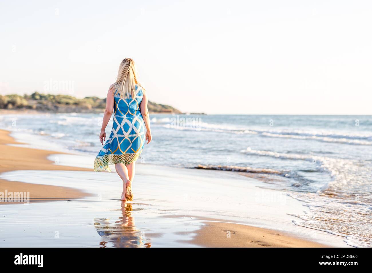 Bella Taglie donna adulta gode di vacanze estive a piedi lungo la spiaggia di sabbia Foto Stock