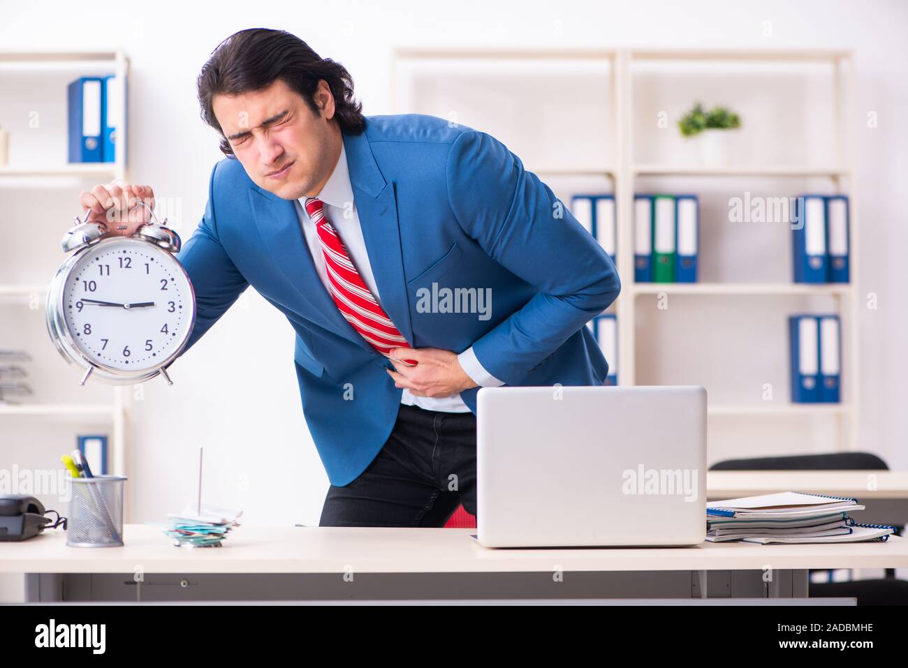 Giovane maschio sofferenza dei dipendenti in ufficio Foto Stock