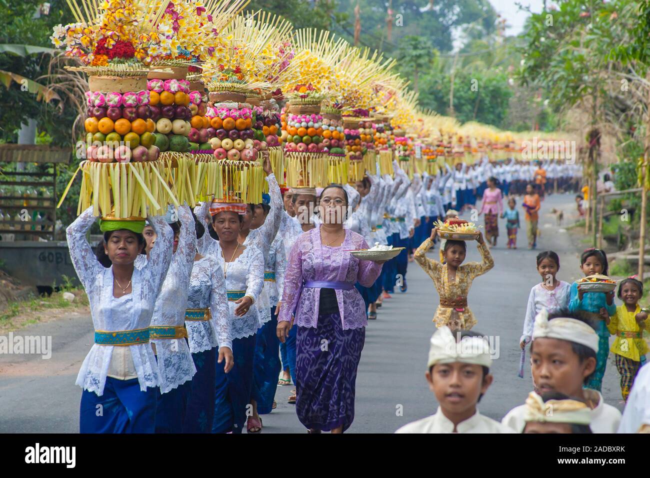 Processione di tradizionalmente condita le donne che trasportano tempio offerte o gebogans sulla loro testa sull'isola di Bali, Indonesia. Foto Stock