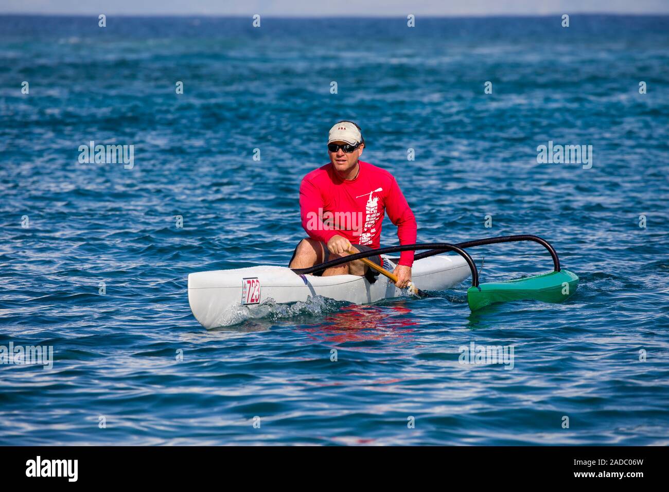 L'uomo paddling da una persona sola canoa outrigger fuori dell'isola di Maui, Hawaii. Immagine modello è rilasciato. Foto Stock