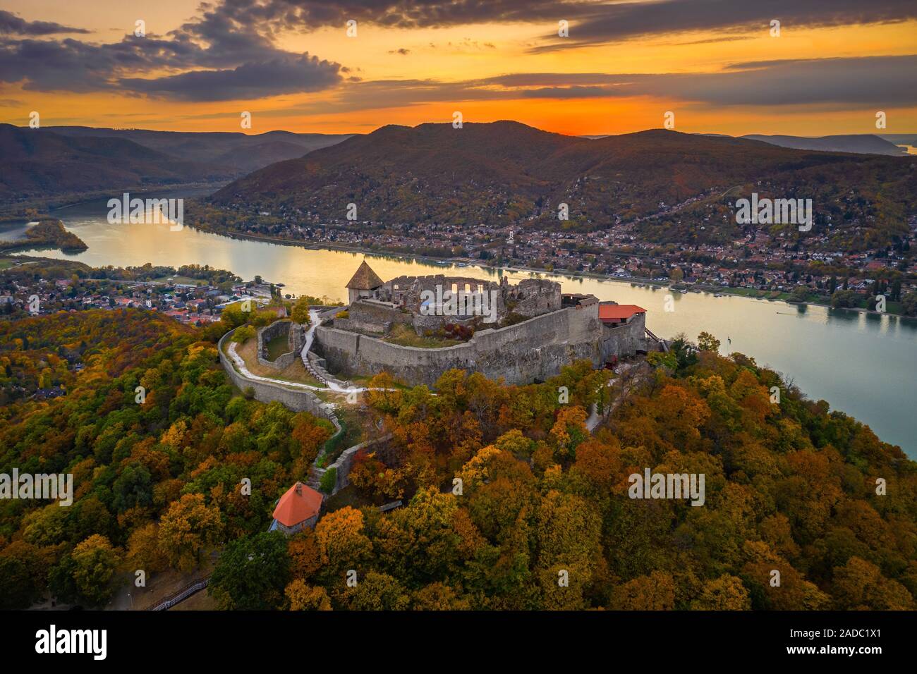 Visegrad, Ungheria - Aerial drone vista sul bellissimo castello di elevata di Visegrad con fogliame di autunno e gli alberi. Dunakanyar e golden sunset a backgrou Foto Stock