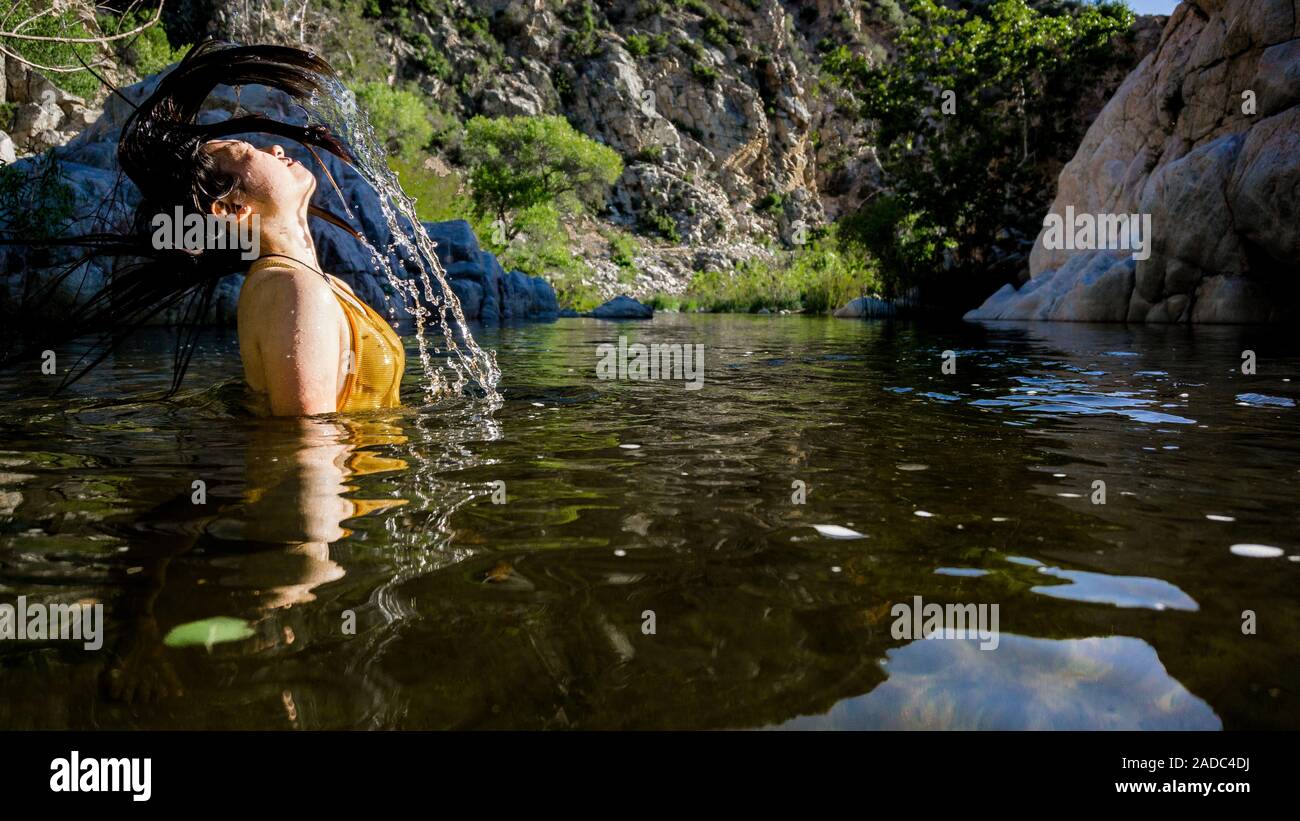 Le donne gli spruzzi di capelli in acqua a deep creek hot springs, STATI UNITI D'AMERICA Foto Stock