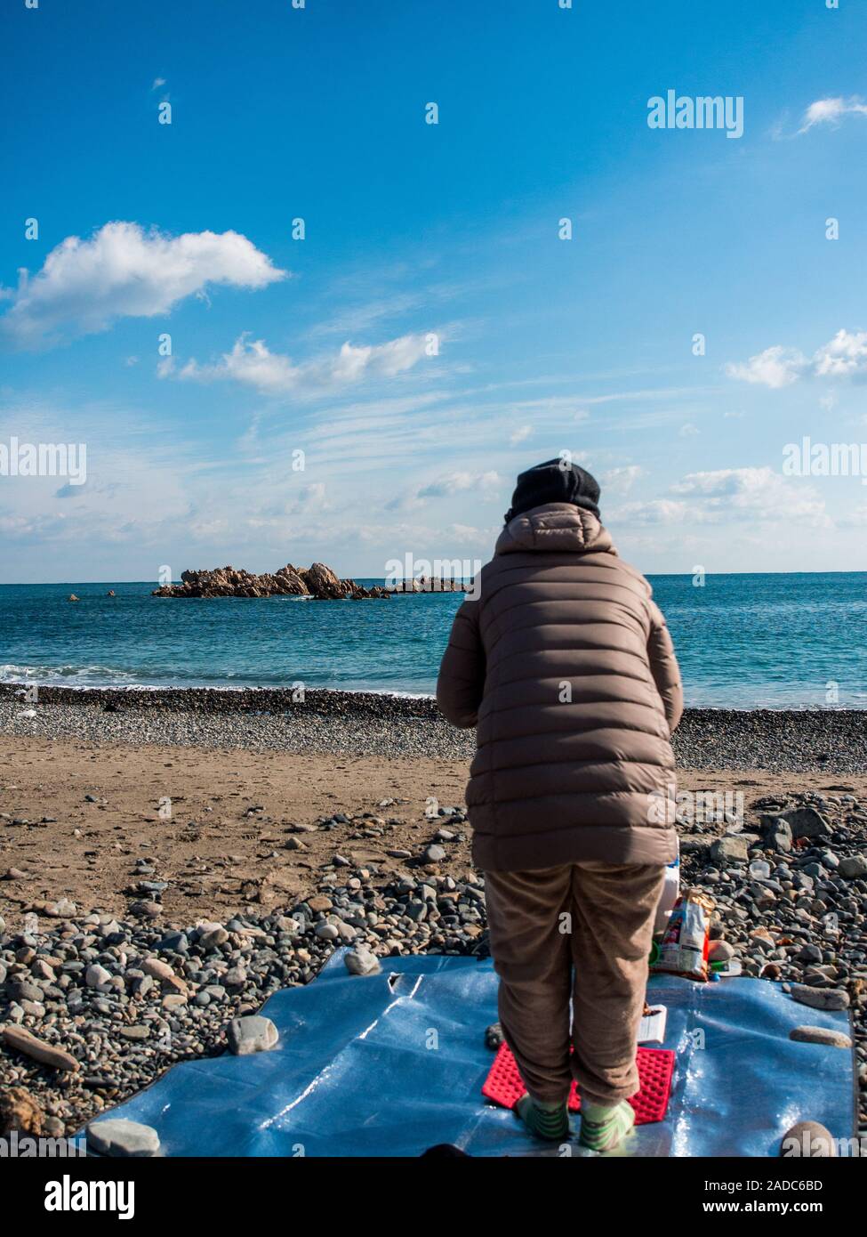 Donna Sciamano eseguendo shamanist rituale, ocean beach, vicino underwater tomba del re Munmu di Silla, segnato da rocce Daewangam, Gyeongju, Corea del Sud Foto Stock