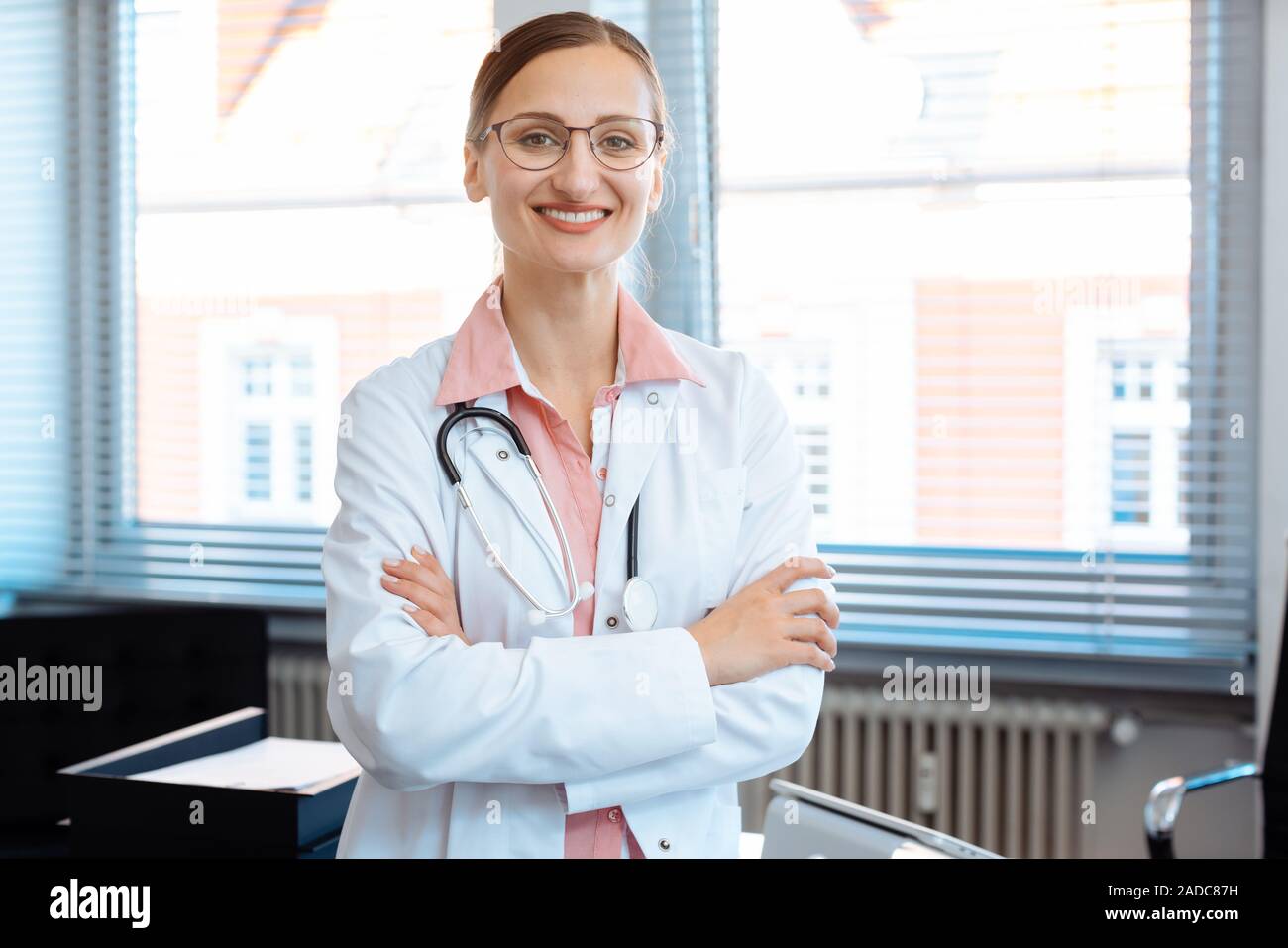 Sorridente medico donna nel suo ufficio Foto Stock