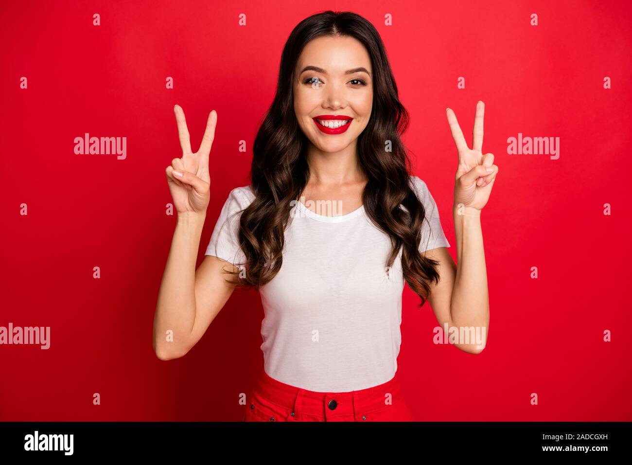 Close-up ritratto di lei bella attraente affascinante carino glamour del grazioso Allegro vivace-ondulato ragazza dai capelli che mostra a doppia v-segno isolato Foto Stock