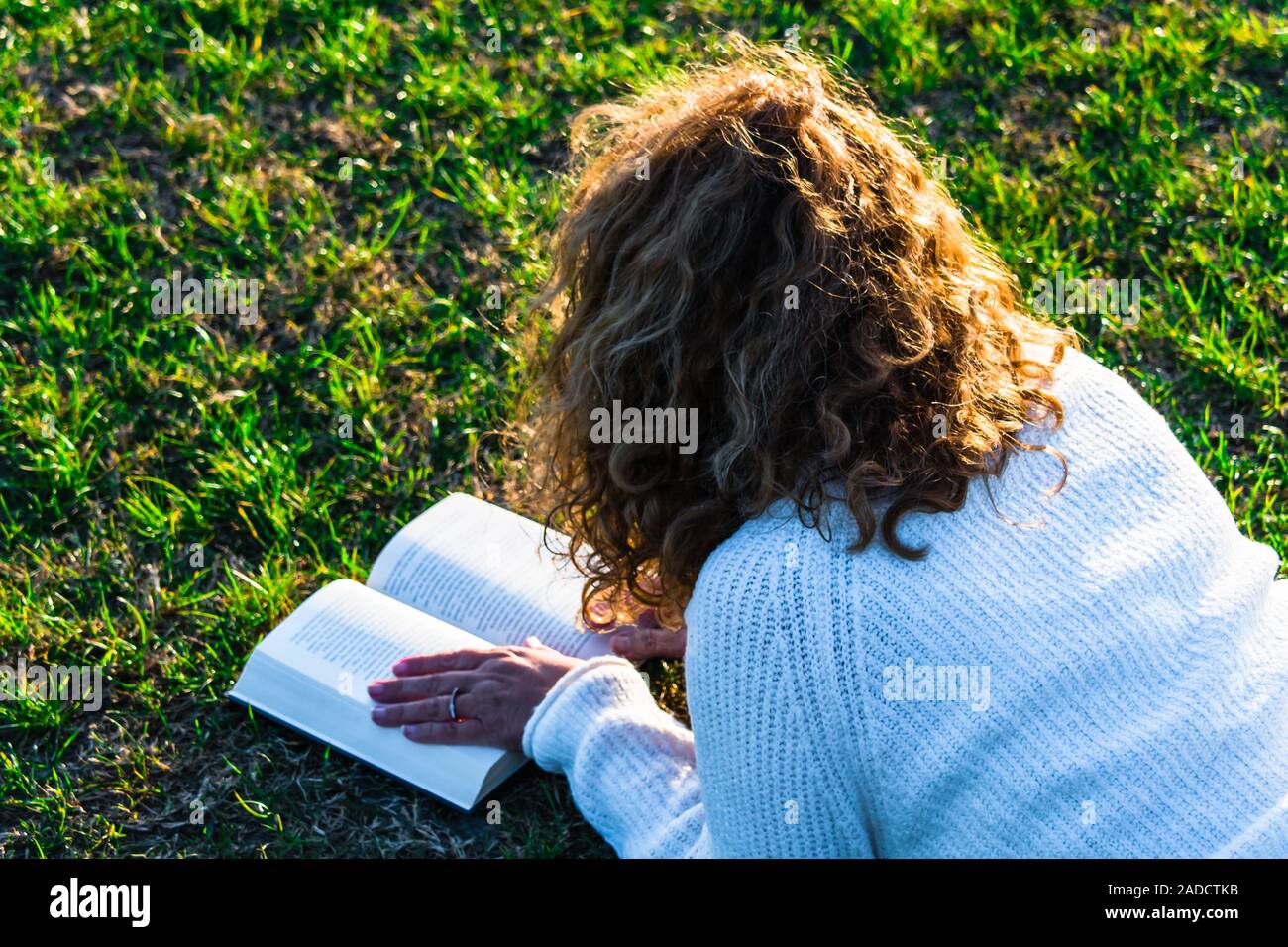 Donna bionda e curly capelli leggere nel parco Foto Stock