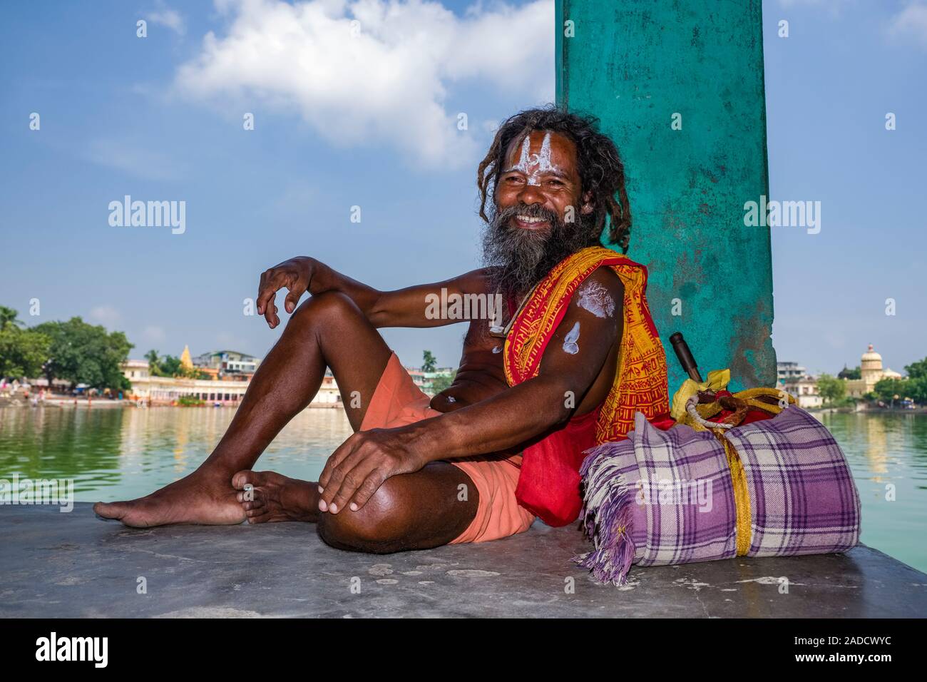 Un Vishnu sadhu, uomo santo, seduto accanto ad un laghetto di acqua Foto Stock
