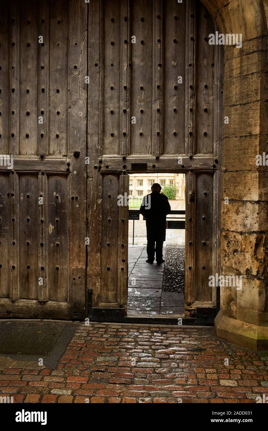 Cancello di ingresso al Trinity College di Cambridge con Bowler cappello porter nel piccolo portale Foto Stock