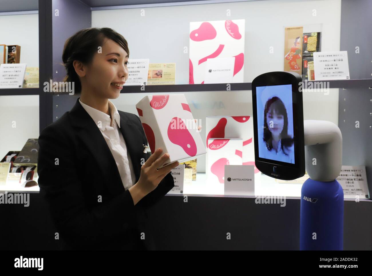 Tokyo, Giappone. 4° dic, 2019. Mitsukoshi department store addetto vendite visualizza una confezione regalo di caramelle di All Nippon Airways (ANA) avatar robot 'newme', 150cm di altezza con un 10 pollici display sulla sua faccia che può essere azionato da un luogo remoto come ANA e magazzino di Mitsukoshi dimostrare un particolare negozio utilizzando newme a Tokyo il Mercoledì, 4 dicembre 2019. I clienti possono godersi lo shopping a casa loro utilizzando avatar robot come ANA e Mitsukoshi si aprirà un negozio speciale di 'avatar-in store' a Tokyo del distretto di Nihonbashi il 5 dicembre attraverso 24. Credito: Yoshio Tsunoda/AFLO/Alamy Live News Foto Stock