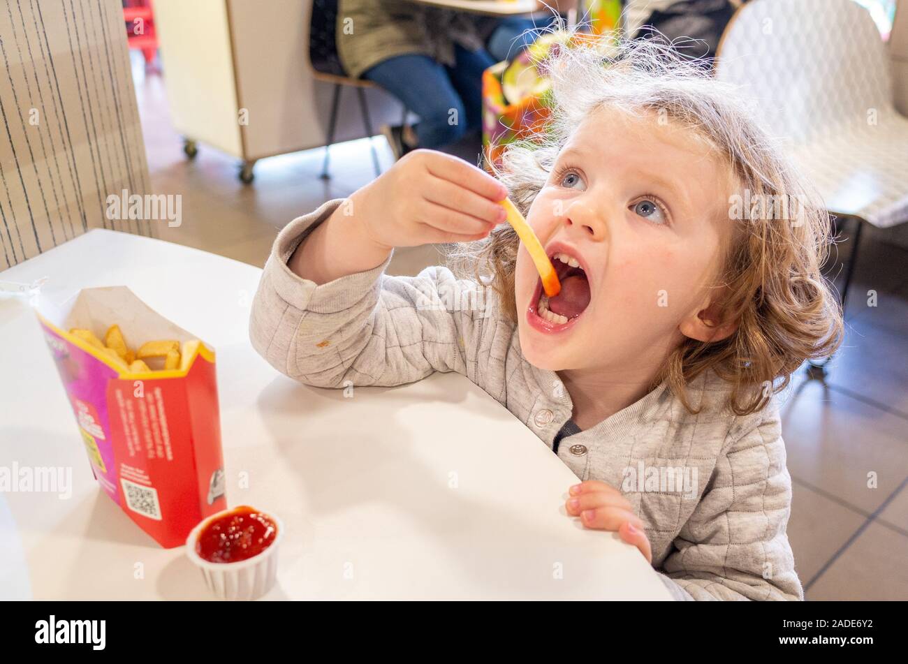 Bambino mangiare McDonald's french fries, REGNO UNITO Foto Stock