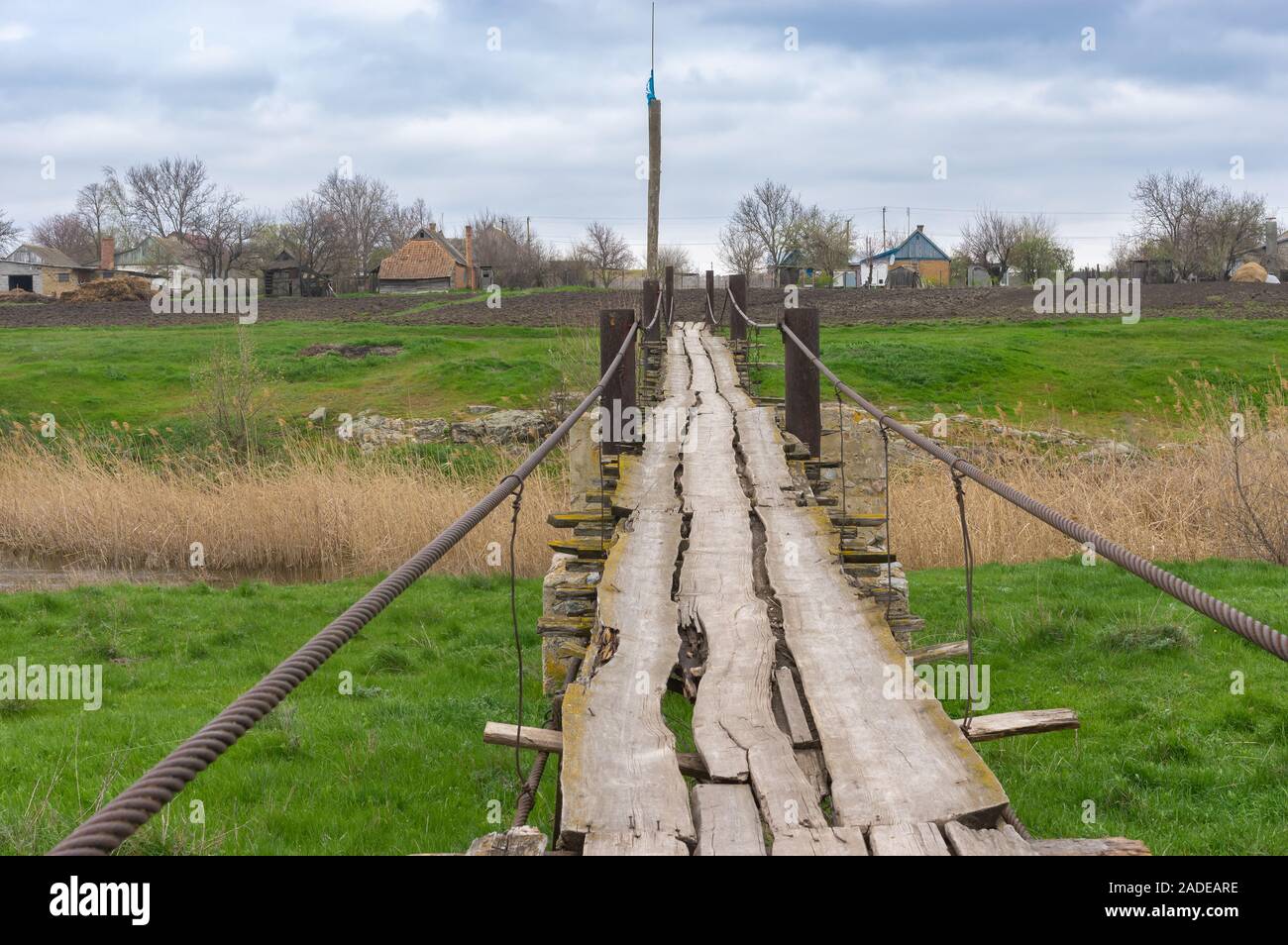 Vecchia pedonale piede legno-ponte sul fiume piccolo Tomakivka nel villaggio Topyla, Ucraina centrale Foto Stock