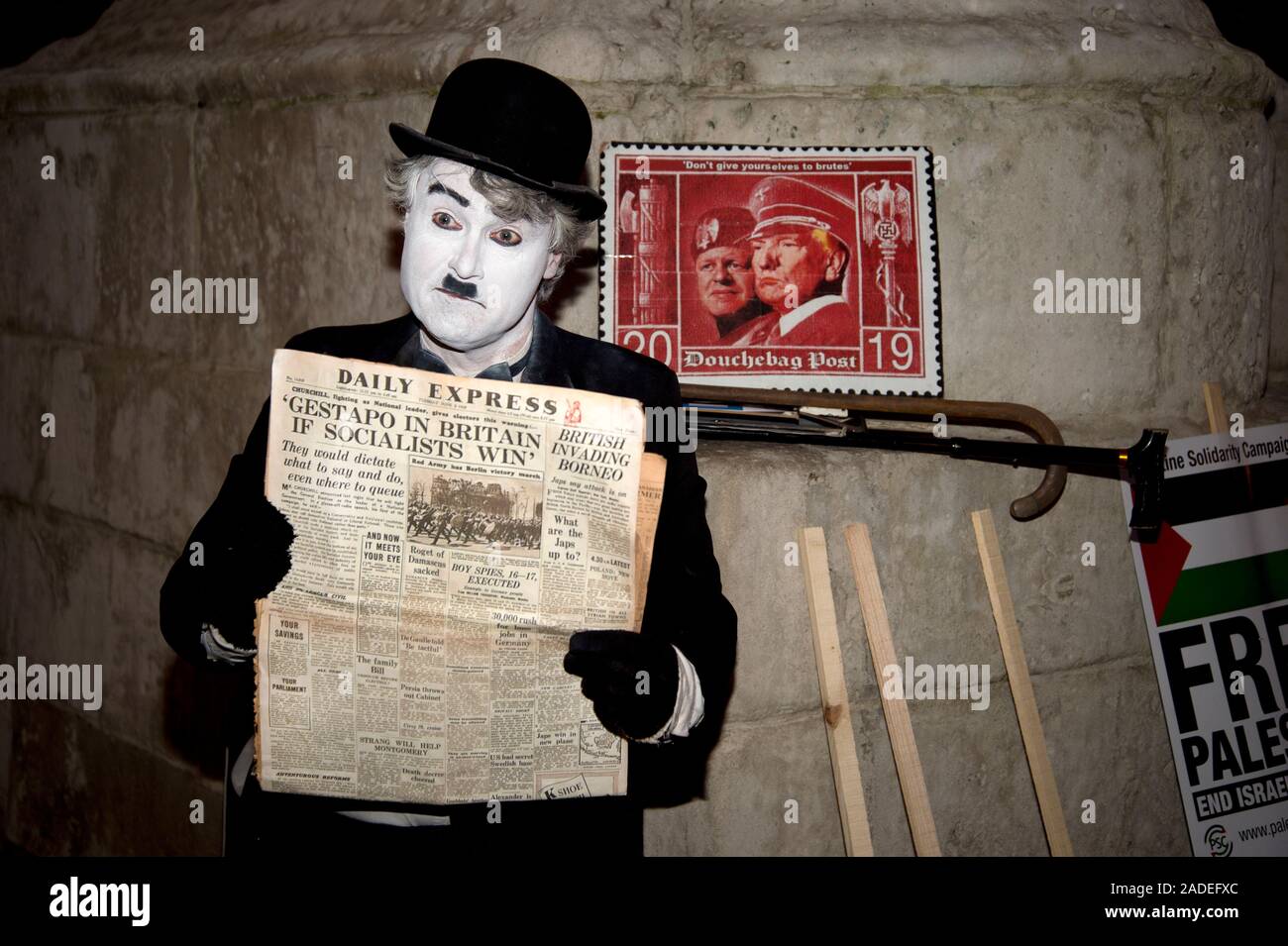 3 dicembre 2019 Trafalgar Square. Anti Trump dimostrazione. Un uomo vestito come Charlie Chaplin contiene una copia del giugno 1945 Daily Express giornale con Foto Stock