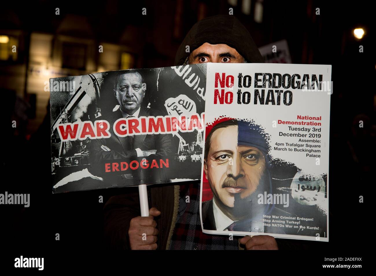3 dicembre 2019 Trafalgar Square. Anti Trump dimostrazione. Un uomo che tiene un cartello che dice Erdogan è un criminale di guerra e non alla Nato Foto Stock