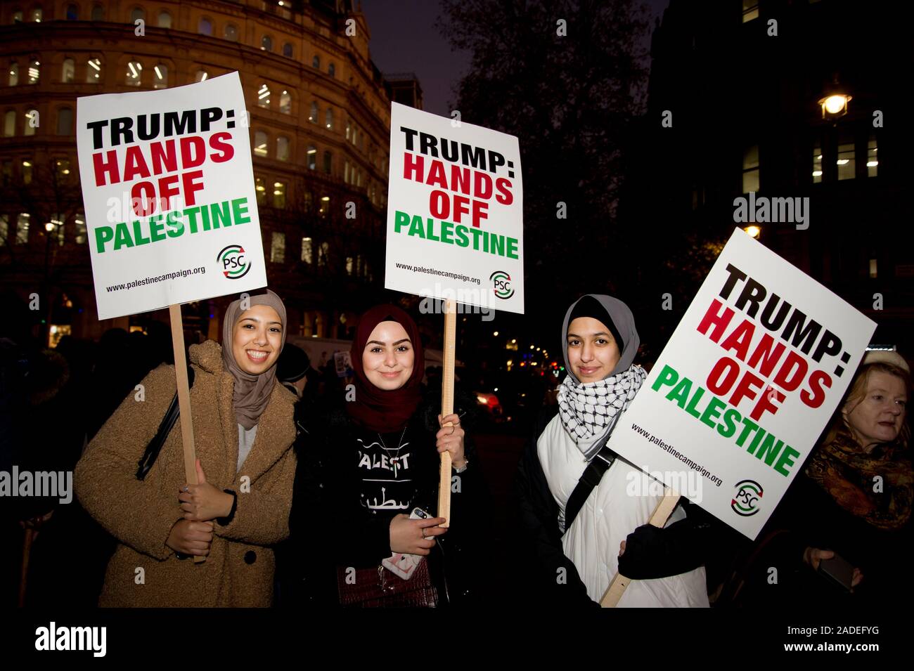 3 dicembre 2019 Trafalgar Square. Anti Trump dimostrazione. Tre giovani donna tenere cartelli dicendo "Trump giù le mani dalla Palestina;". Foto Stock