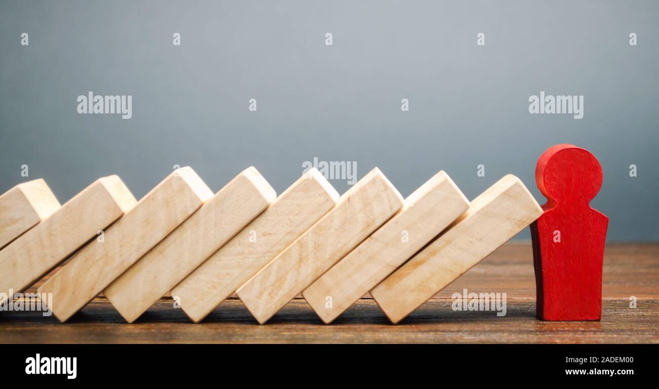 Imprenditore si arresta la caduta di domino. La gestione del rischio concetto. Forte di successo di business e di problem solving. Leader affidabile. Arrestare il proce distruttivo Foto Stock