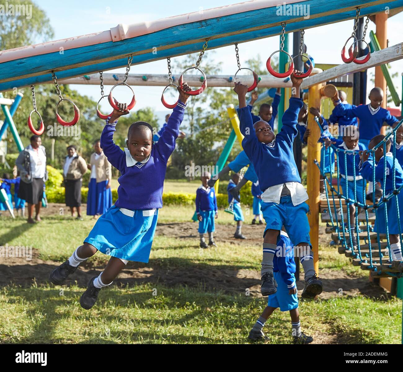 Scolare la riproduzione sul telaio di arrampicata in schoolyard, Mirisa Academy, Nakuru, Kenya Foto Stock