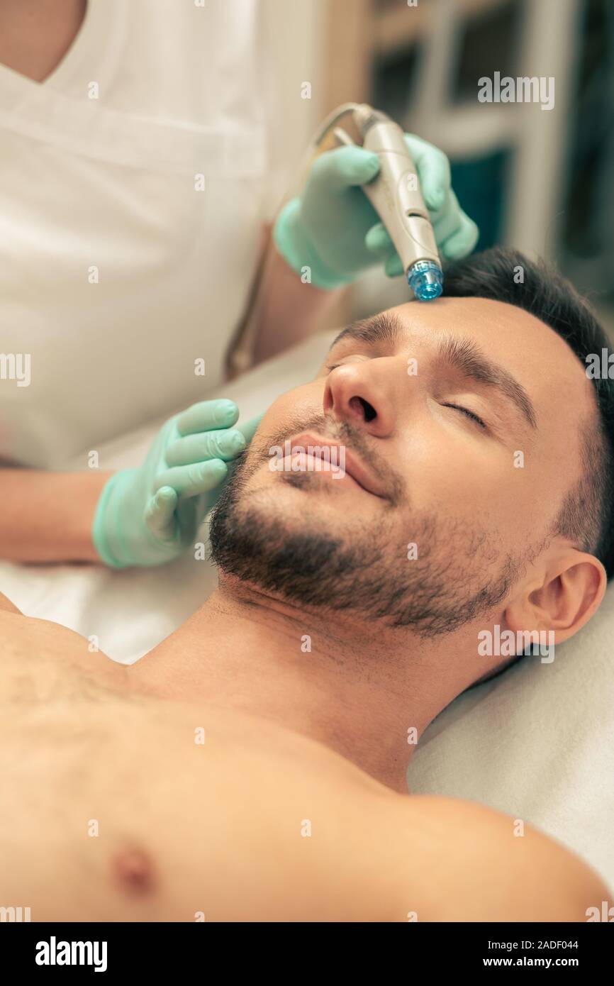 Rilassata giovane godendo di nutrienti della pelle procedura Foto Stock