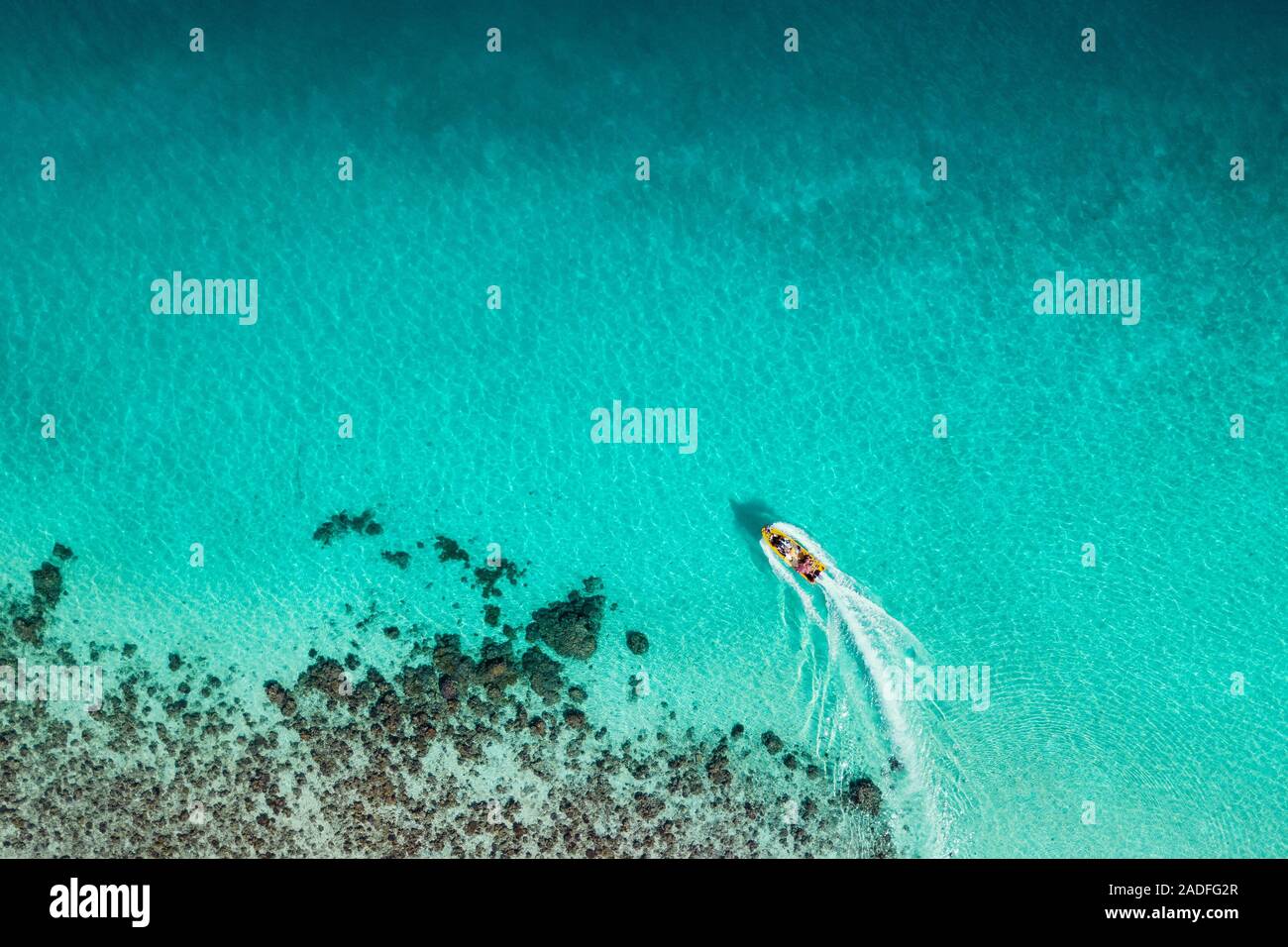 Vista aerea di imbarcazione turistica sulla superficie di incredibile tropicale oceano turchese costa con barriera corallina. Aqua Menthe colore alla moda del nuovo anno 2020. Foto Stock