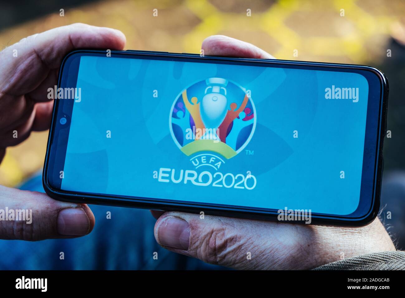L'uomo anziano è in possesso di uno smartphone con il logo di UEFA EURO 2020 sullo schermo Foto Stock
