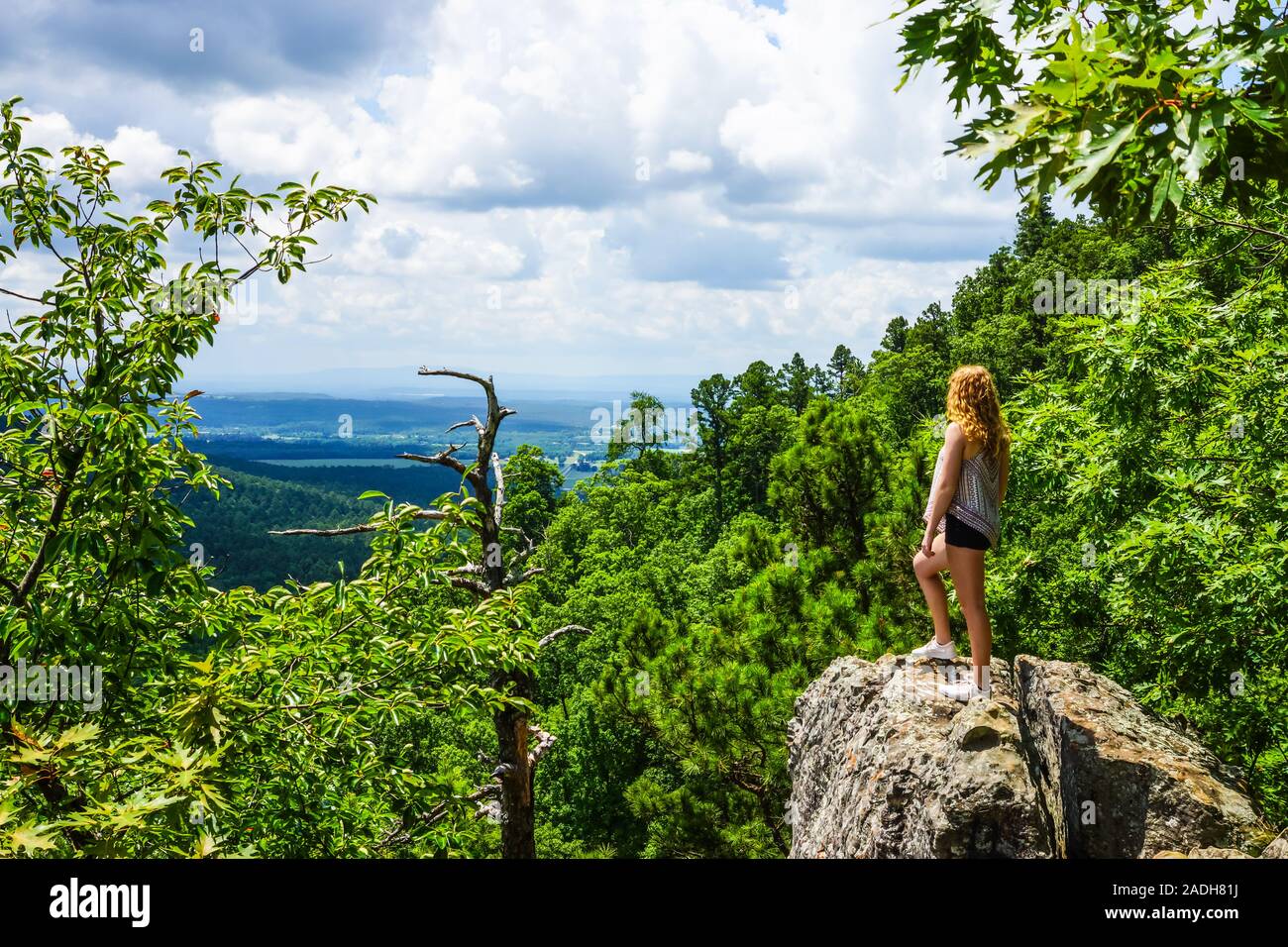 Una ragazza sorge su una rupe di roccia che si affaccia sulla Ozark Mountains nello stato di Arkansas, Stati Uniti. Foto Stock