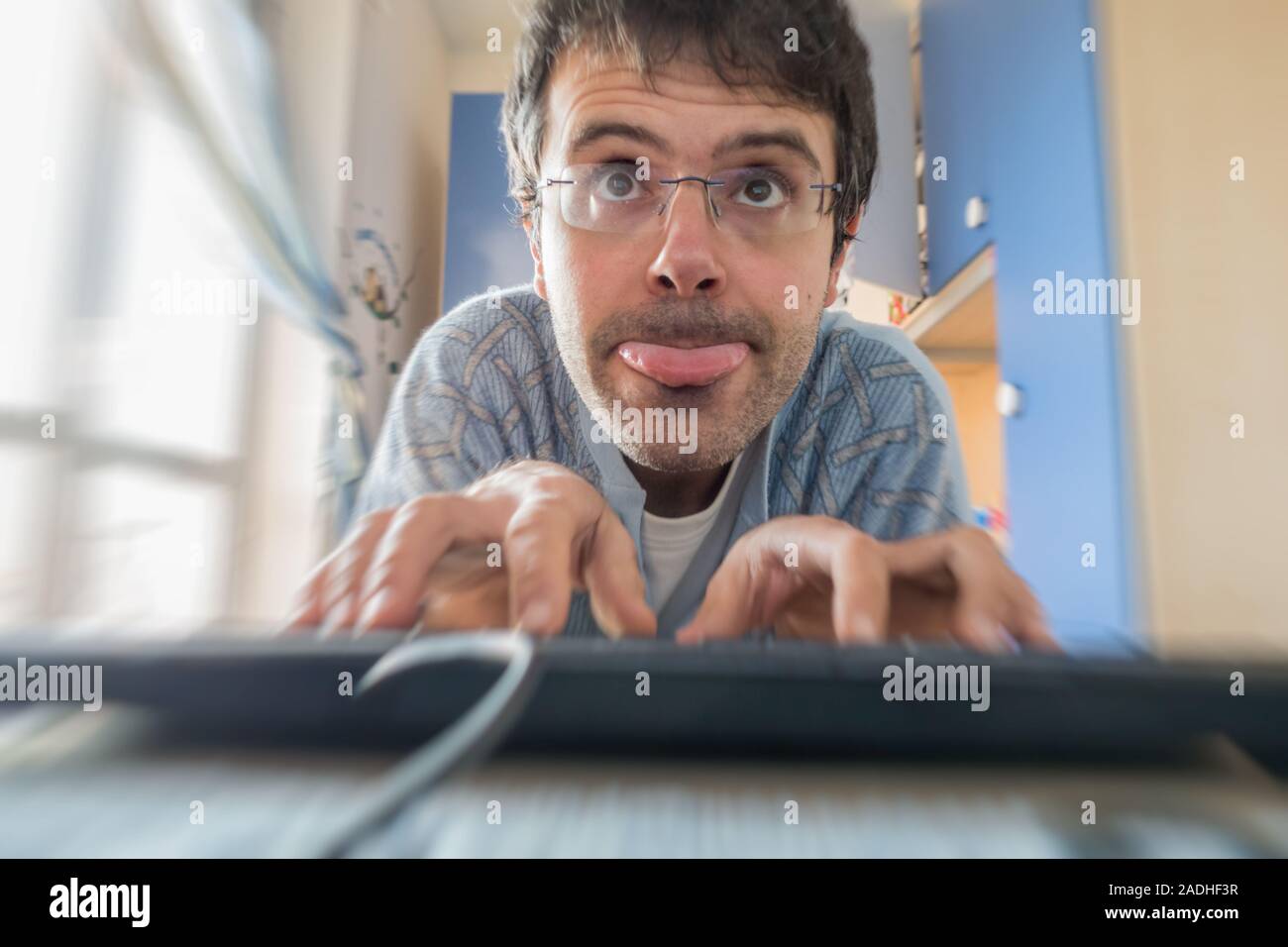 Giovane uomo in pigiama addicted a computer e smartphone in camera da letto.Concetto di dipendenza dalle tecnologie e la mancanza di vita sociale Foto Stock