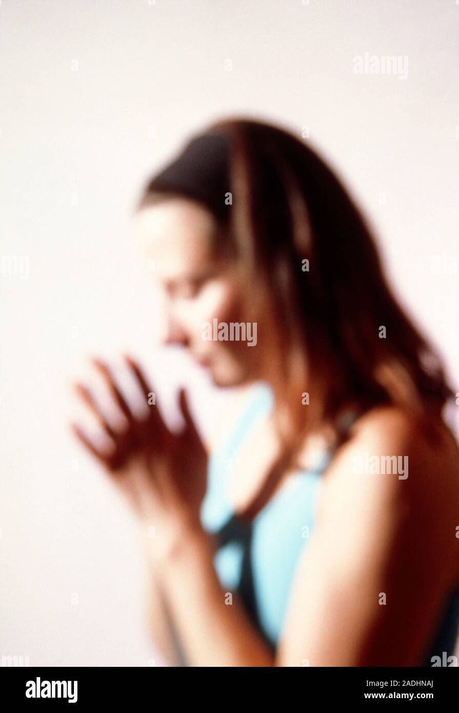 Premurosa donna. Premurosa donna con gli occhi chiusi e le palme delle mani premuti insieme. Foto Stock