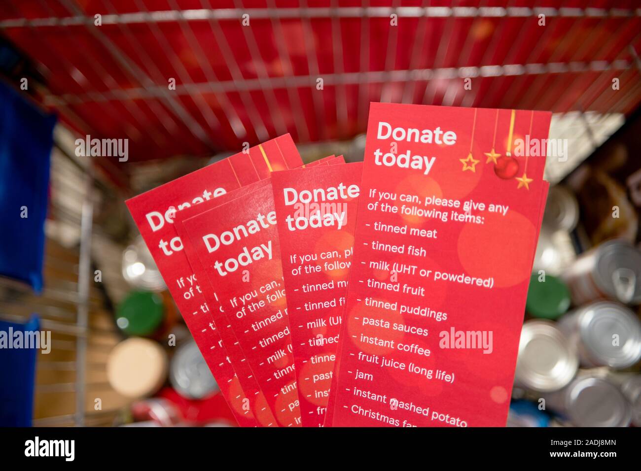 Donazione volantini per una banca alimentare al di sopra di un carrello di Tins Foto Stock