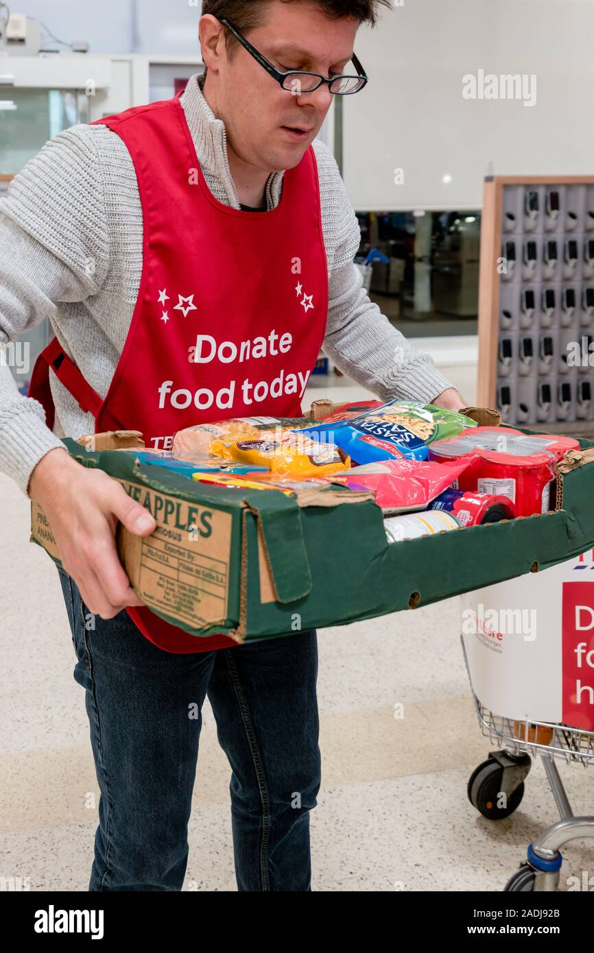 Un volontario che porta una scatola di donazioni presso il National food bank per la raccolta Trussell foodbanks Trust Foto Stock