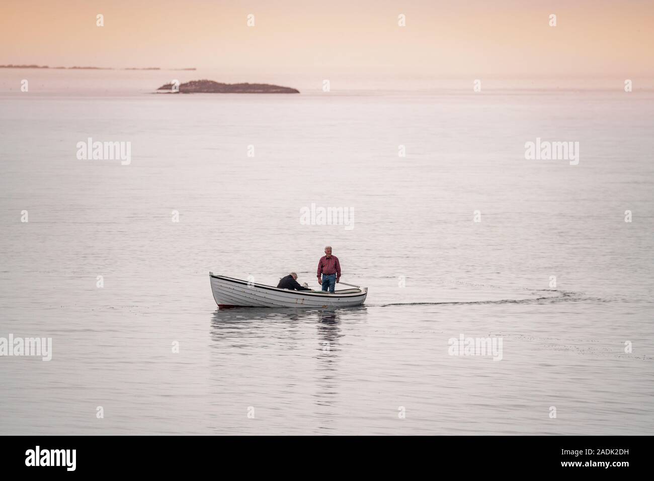 Gli uomini in una barca a remi, Flatey isola nel Breidafjordur, Westfjords, Islanda Foto Stock