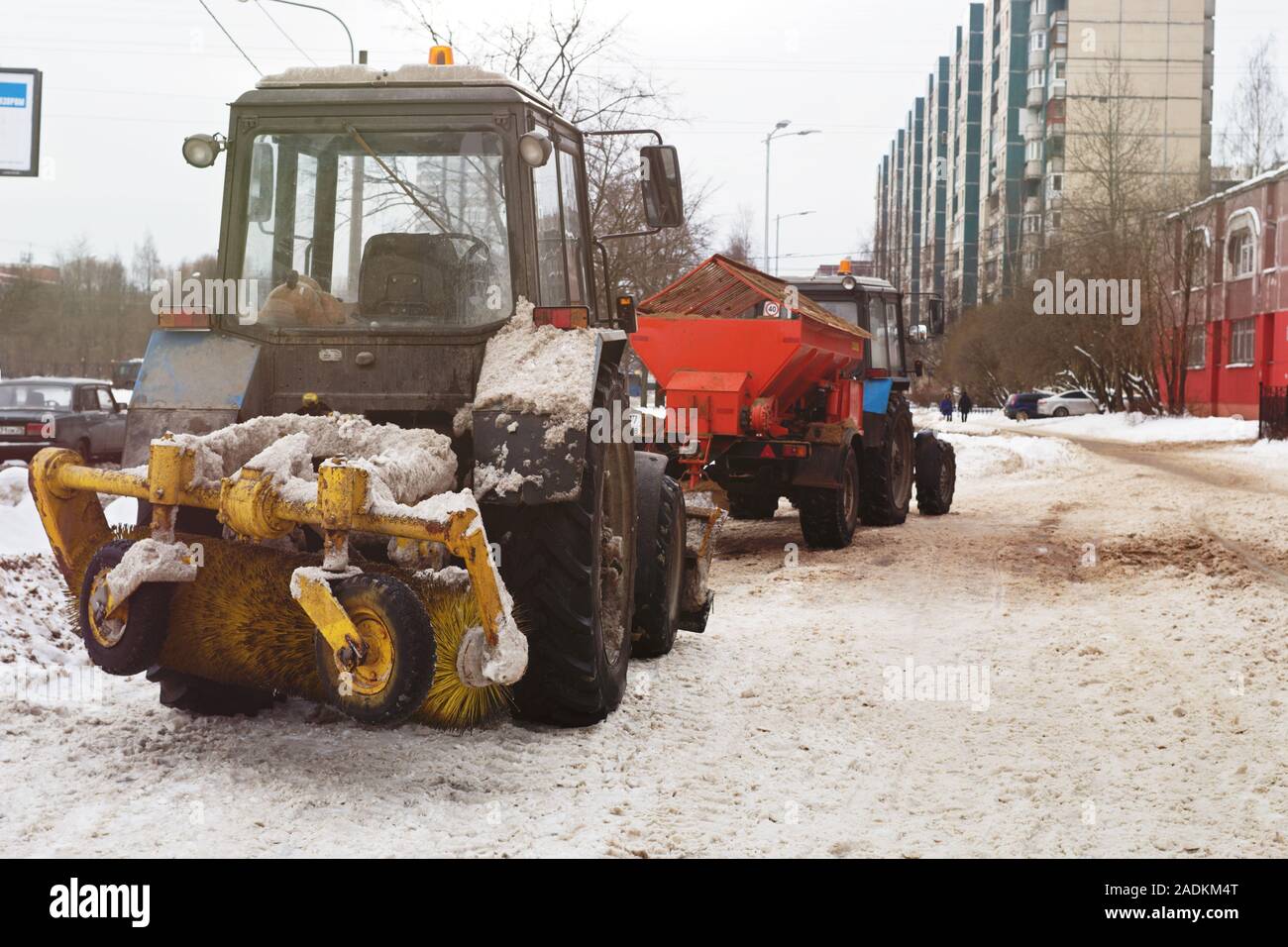 Rimozione della neve in città e la trasformazione di marciapiedi agente contro il ghiaccio Foto Stock