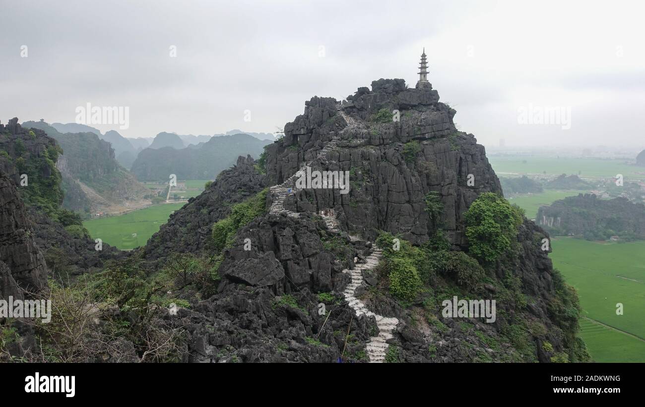 Una vista del picco di una montagna e un percorso per il vertice nel bellissimo paesaggio del Tam Coc, Ninh Binh, Vietnam Foto Stock