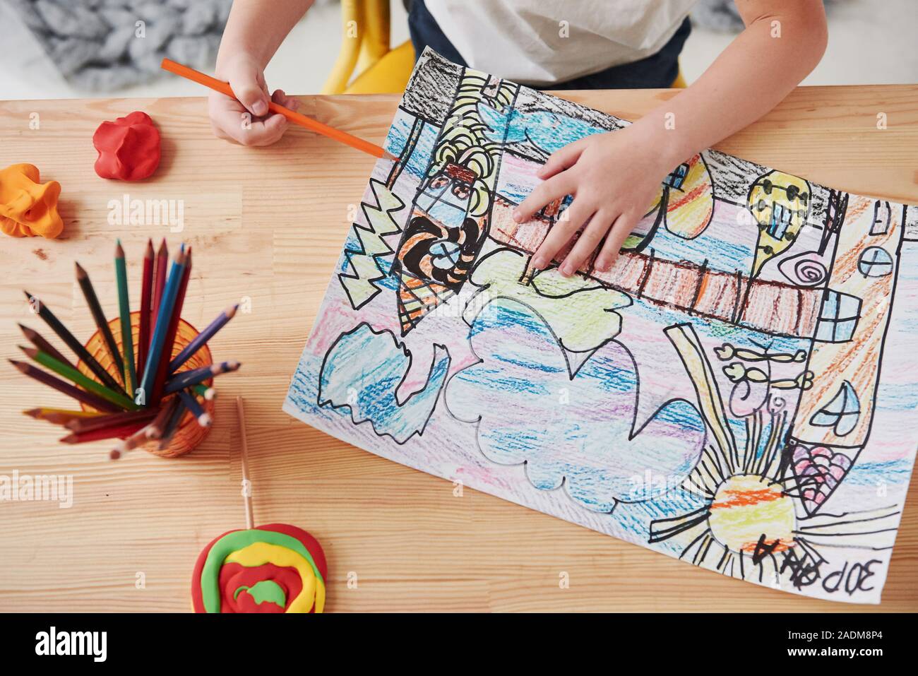 Foto di particelle. Carino bambina nella scuola di arte trae i suoi primi dipinti di matite e marcatori Foto Stock