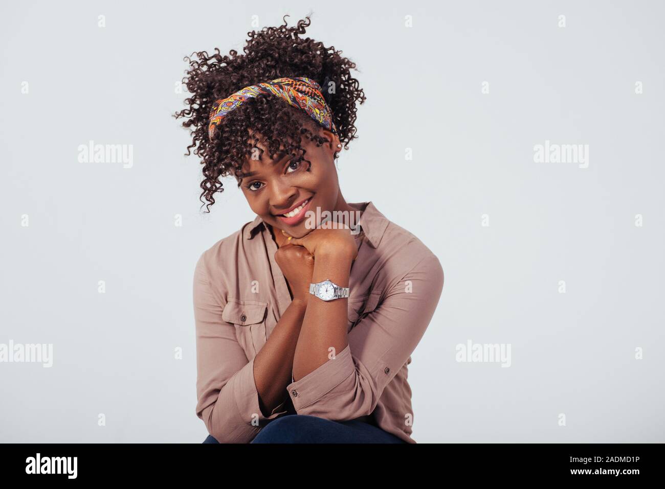Nizza cutie. Bella afro american ragazza con i capelli ricci in studio con sfondo bianco Foto Stock