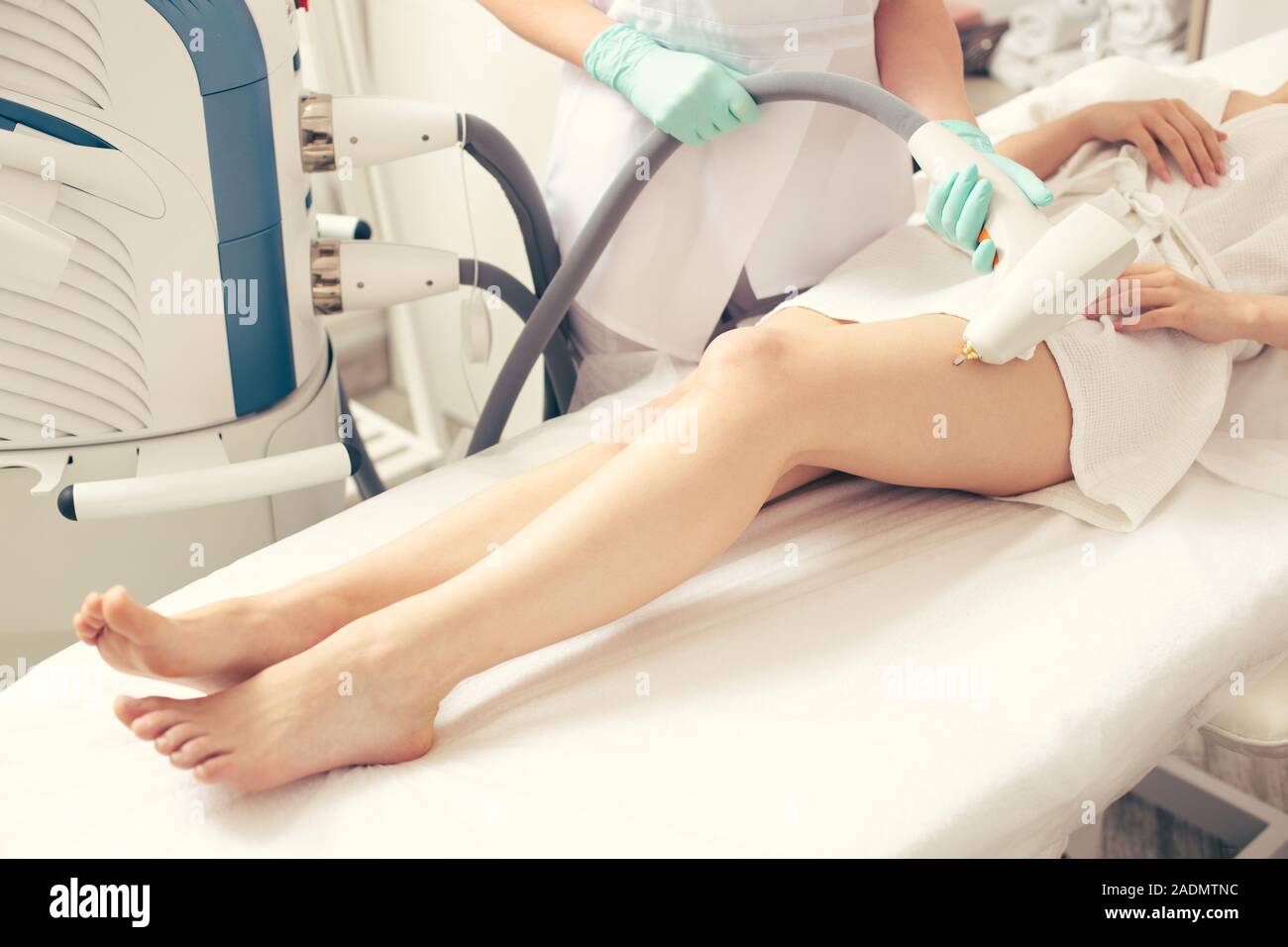 Le gambe della signora giovane e sanitario di toccarli con il moderno strumento Foto Stock