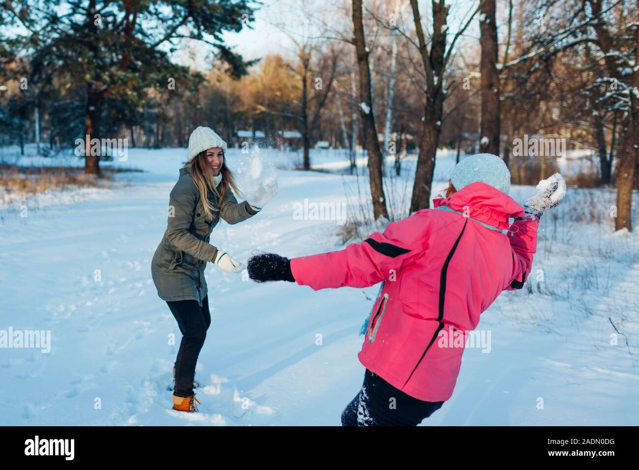 Snowballs giocando nella foresta d'inverno. Famiglia madre e figlia divertirsi gettando la neve all'aperto Foto Stock